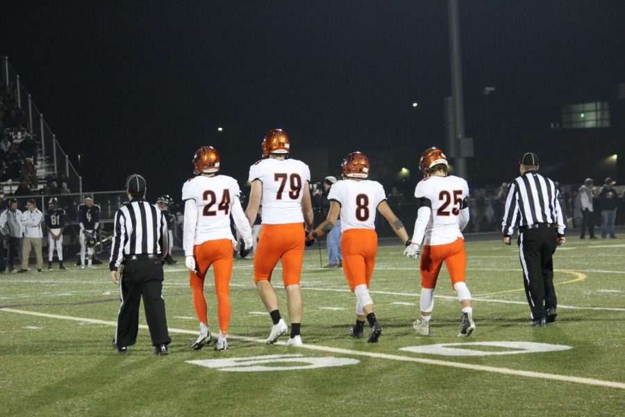 Captains Alex Mathis, Cameron Marcucci, Noah Roper, and Jaden Gilmore walk into the field for the coin toss