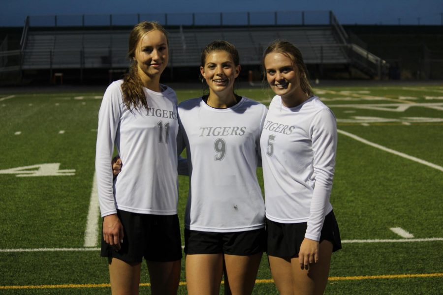 From left to right: Seniors Adlee Schenbeck, Elise Capra, and Kennedy Sakalosky stand together after winning their last home game.